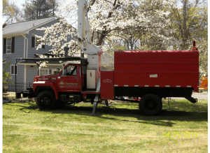 Red cherry picker truck in front of house